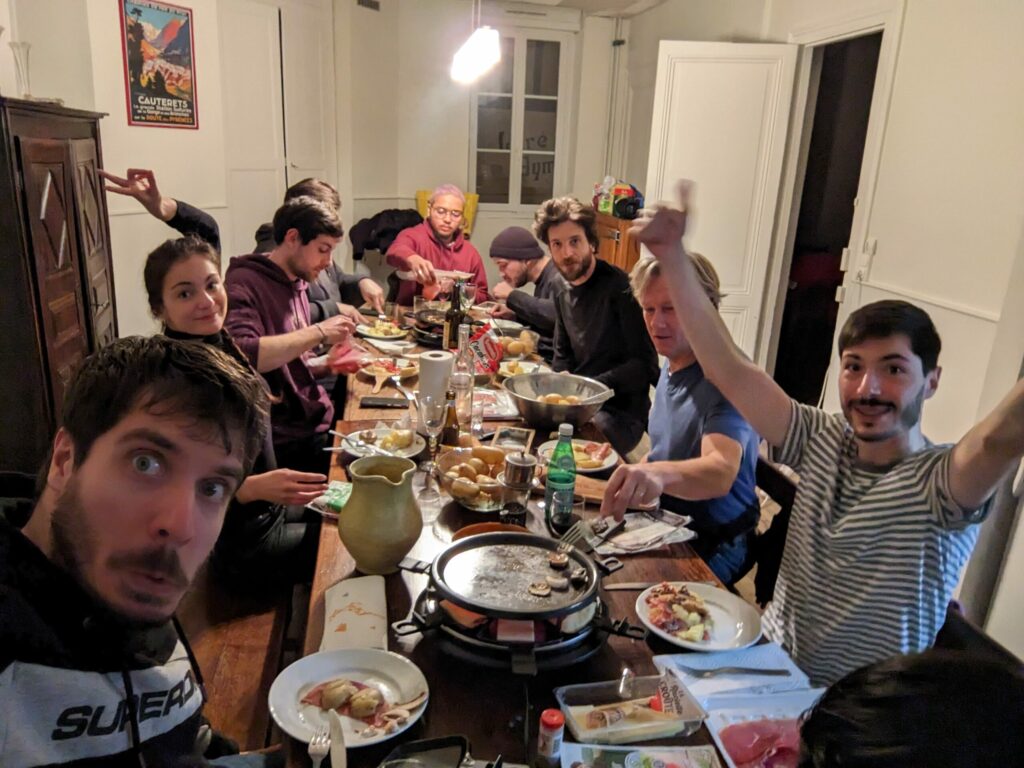 personnes autour d'une table mangeant de la raclette